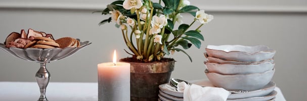 Produktbilde av servise og pyntegjenstander på et bord med hvit duk